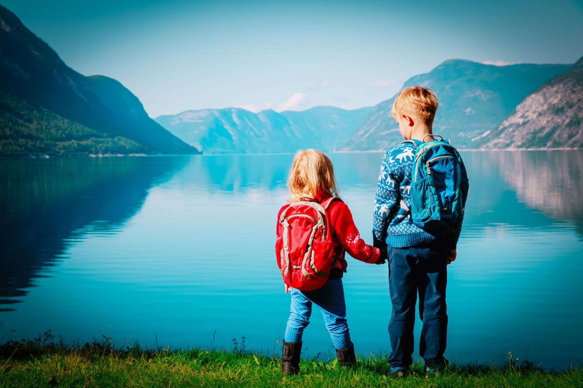 tyttö ja poika pitävät käsistään kiinni katsoen järvelle